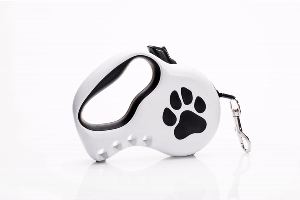 White retractable dog leash with black paw print design on a white background.